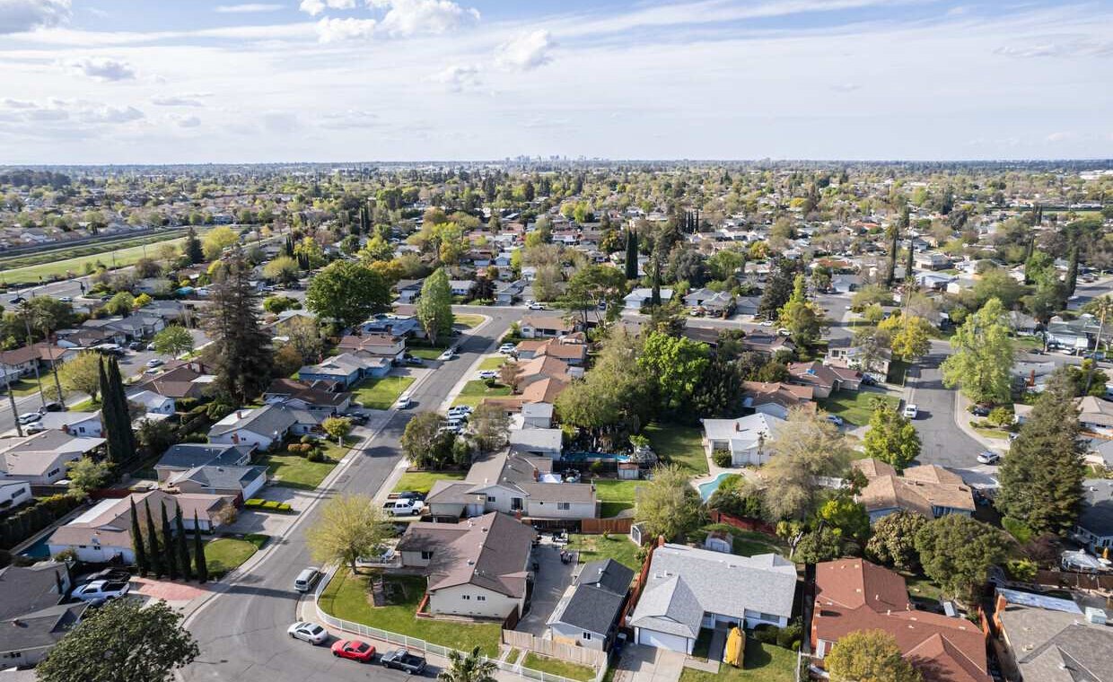 An aerial view of a leafy Sacramento neighborhood of kept lawns and tree-lined streets